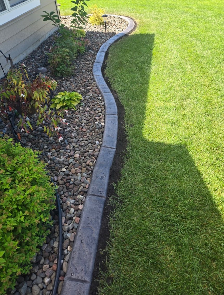 Landscape edging with river rock installation in Edmonton